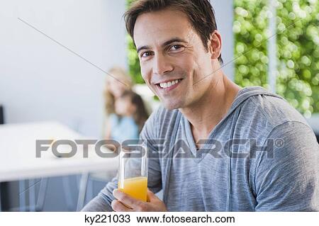 Man holding a glass of juice View Large Photo Image Stock Image - Man holding a glass of juice. Fotosearch