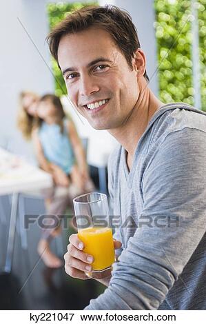 Stock Photo - Man holding a glass of juice. Fotosearch