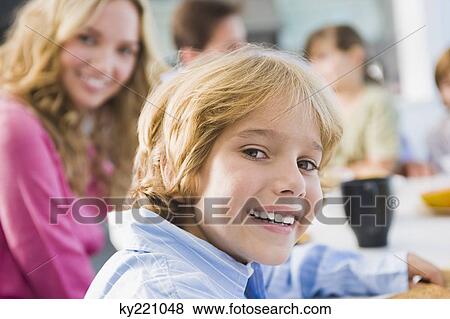 Portrait of a boy at a dining table and smiling View Large Photo Image Stock Photo - Portrait of a boy at a dining table and smiling. Fotosearch