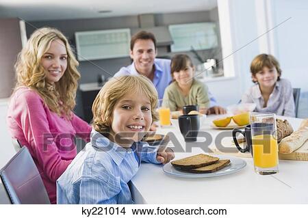 Picture - Portrait of a family having breakfast and smiling. Fotosearch