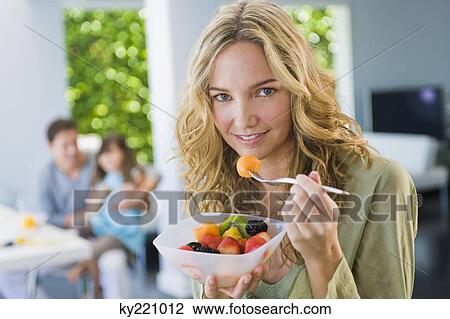 Woman eating fruit salad View Large Photo Image Stock Image - Woman eating fruit salad. Fotosearch