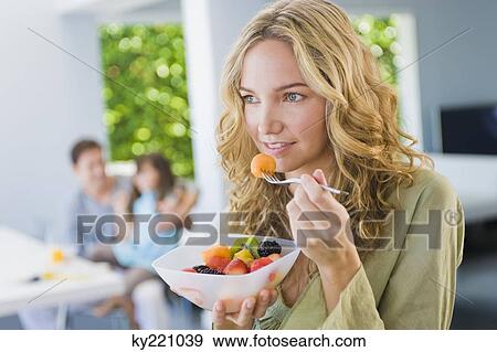 Stock Photo - Woman eating fruit salad. Fotosearch