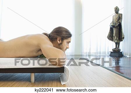 Stock Image - Man lying on a massage table. Fotosearch