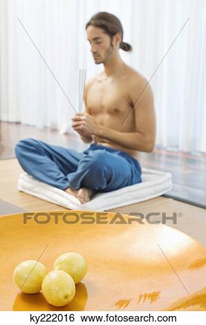 Man practicing yoga and holding incense sticks View Large Photo Image Stock Photograph - Man practicing yoga and holding incense sticks. Fotosearch
