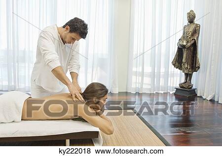Man receiving a back massage from a massage therapist View Large Photo Image Stock Photo - Man receiving a back massage from a massage therapist. Fotosearch