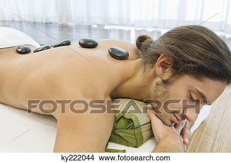 Man receiving hot stone therapy View Large Photo Image Picture - Man receiving hot stone therapy. Fotosearch