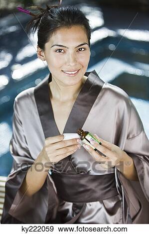 Woman holding a bottle of aromatherapy oil and smiling View Large Photo Image Stock Photo - Woman holding a bottle of aromatherapy oil and smiling. Fotosearch