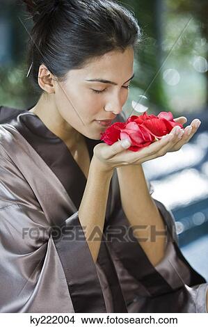 Picture - Woman smelling rose flowers. Fotosearch