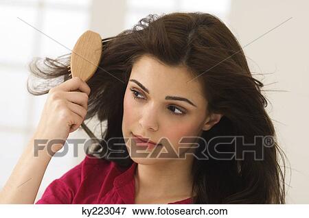 Stock Photo - Close-up of a woman brushing her hair. Fotosearch