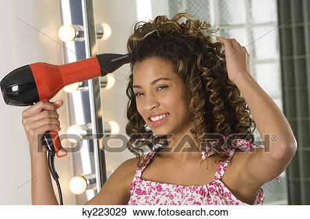 Stock Photo - Girl holding a hair dryer. Fotosearch