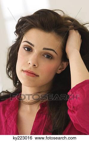 Portrait of a woman with her hand in her hair View Large Photo Image Stock Photograph - Portrait of a woman with her hand in her hair. Fotosearch