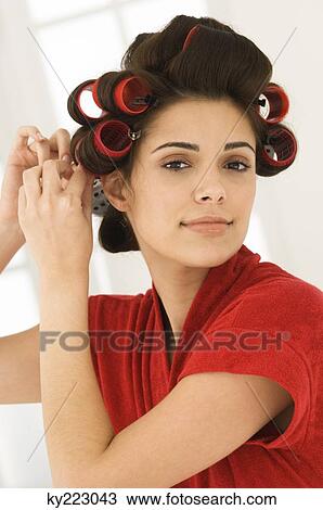 Woman adjusting curlers in her hair View Large Photo Image Stock Image - Woman adjusting curlers in her hair. Fotosearch