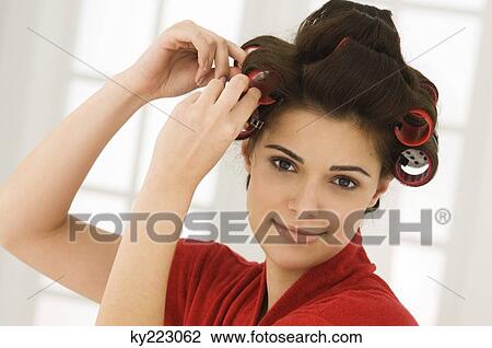 Woman adjusting curlers in her hair View Large Photo Image Stock Image - Woman adjusting curlers in her hair. Fotosearch