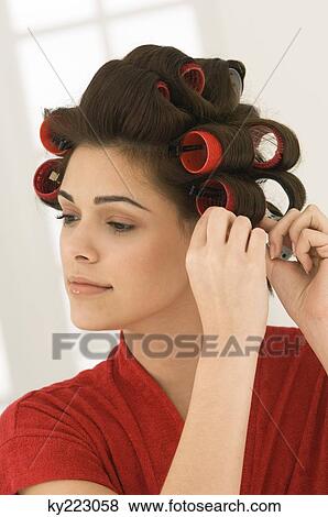 Woman adjusting curlers in her hair View Large Photo Image Stock Photo - Woman adjusting curlers in her hair. Fotosearch