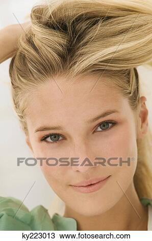 Stock Image - Woman with her hand in her hair. Fotosearch