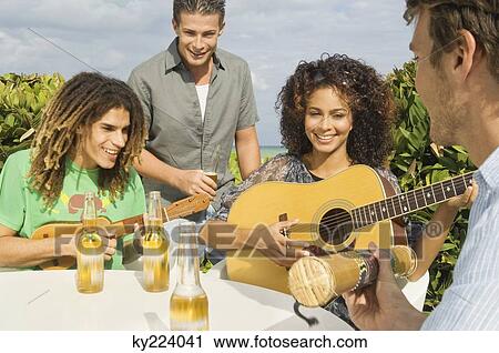 Friends enjoying beer and music on vacations View Large Photo Image Stock Image - Friends enjoying beer and music on vacations. Fotosearch