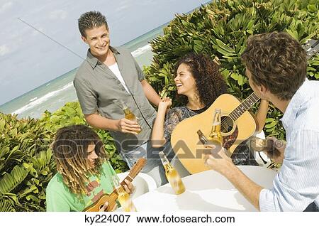 Friends enjoying beer and music on vacations View Large Photo Image Stock Photo - Friends enjoying beer and music on vacations. Fotosearch