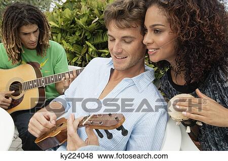 Stock Photo - Friends playing musical instruments. Fotosearch