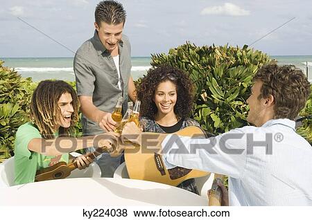 Friends toasting with beer bottles View Large Photo Image Stock Photo - Friends toasting with beer bottles. Fotosearch