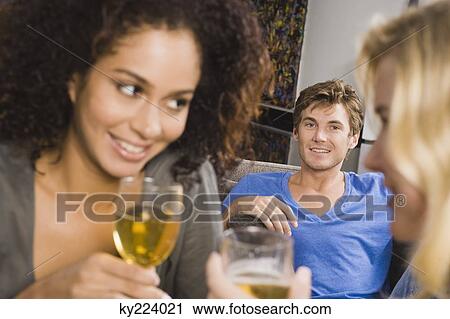 Three friends enjoying drinks at a party View Large Photo Image Stock Image - Three friends enjoying drinks at a party. Fotosearch