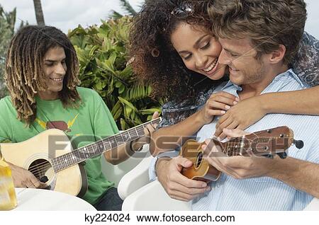 Woman embracing a man playing ukulele View Large Photo Image Picture - Woman embracing a man playing ukulele. Fotosearch