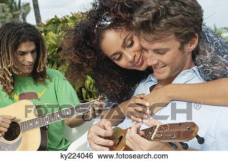 Woman embracing a man playing ukulele View Large Photo Image Stock Photograph - Woman embracing a man playing ukulele. Fotosearch