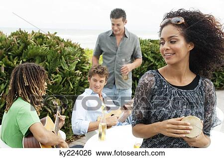 Woman playing drum with her friends playing guitars View Large Photo Image Stock Photograph - Woman playing drum with her friends playing guitars. Fotosearch