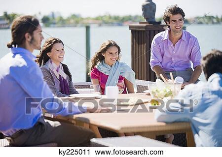 Friends having lunch at a sidewalk cafe View Large Photo Image Stock Image - Friends having lunch at a sidewalk cafe. Fotosearch