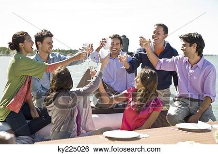 Stock Photograph - Friends toasting with drinks at a party. Fotosearch