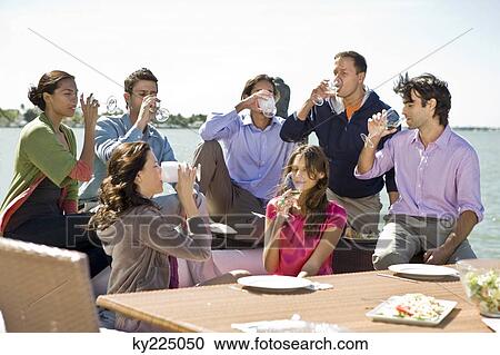 Group of friends enjoying drinks at a party View Large Photo Image Stock Image - Group of friends enjoying drinks at a party. Fotosearch