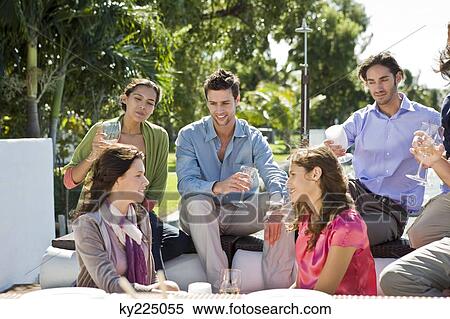 Group of friends enjoying drinks at a party View Large Photo Image Stock Photography - Group of friends enjoying drinks at a party. Fotosearch