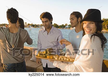 Picture - Portrait of a woman serving fruits and smiling. Fotosearch