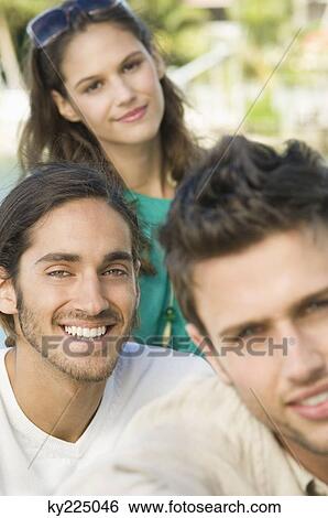 Stock Photograph - Portrait of three friends smiling. Fotosearch