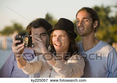 Three friends taking a picture of themselves View Large Photo Image Stock Photo - Three friends taking a picture of themselves. Fotosearch