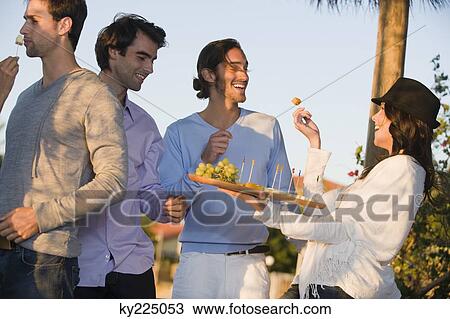 Woman serving fruits to her friends View Large Photo Image Stock Image - Woman serving fruits to her friends. Fotosearch