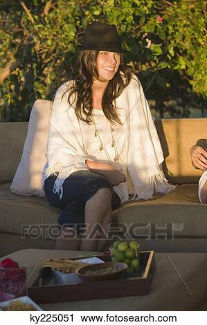 Woman sitting on a couch and smiling View Large Photo Image Stock Image - Woman sitting on a couch and smiling. Fotosearch