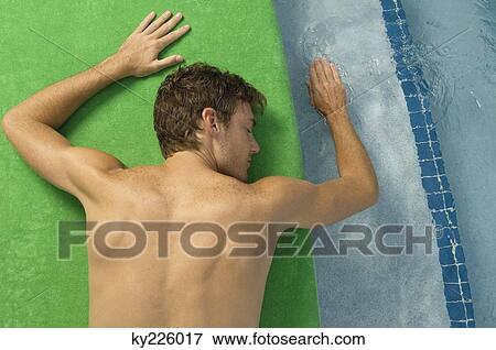 High angle view of a man sunbathing at the poolside View Large Photo Image Stock Photo - High angle view of a man sunbathing at the poolside. Fotosearch