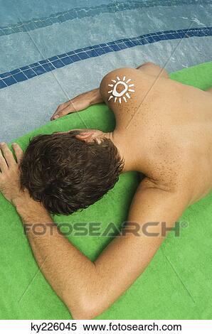 High angle view of a man sunbathing at the poolside View Large Photo Image Stock Photography - High angle view of a man sunbathing at the poolside. Fotosearch