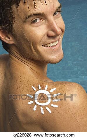 Stock Photo - Man with sun shape on his shoulder at the poolside. Fotosearch