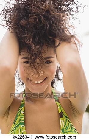 Portrait of a woman holding her hair and smiling View Large Photo Image Stock Image - Portrait of a woman holding her hair and smiling. Fotosearch