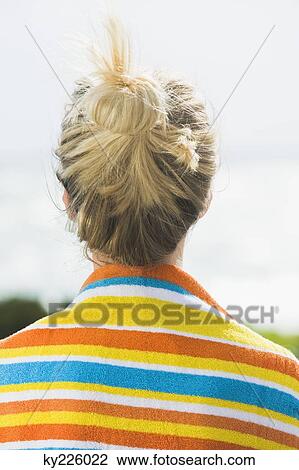Rear view of a woman with a beach towel around shoulders View Large Photo Image Stock Image - Rear view of a woman with a beach towel around shoulders. Fotosearch