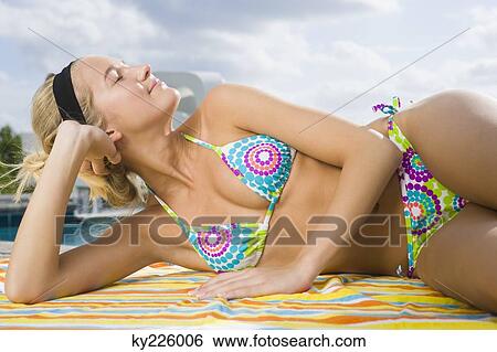 Stock Photograph - Woman day dreaming at the poolside. Fotosearch