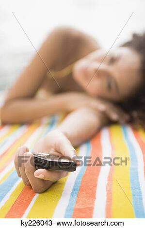 Woman lying at the poolside and holding a mobile phone View Large Photo Image Stock Image - Woman lying at the poolside and holding a mobile phone. Fotosearch