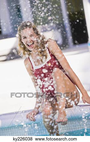 Woman sitting at the poolside and splashing water View Large Photo Image Stock Photo - Woman sitting at the poolside and splashing water. Fotosearch