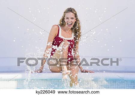 Woman sitting at the poolside and splashing water View Large Photo Image Stock Photo - Woman sitting at the poolside and splashing water. Fotosearch