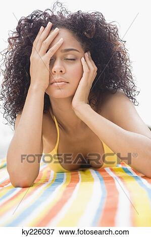 Woman sunbathing at the poolside View Large Photo Image Stock Photo - Woman sunbathing at the poolside. Fotosearch