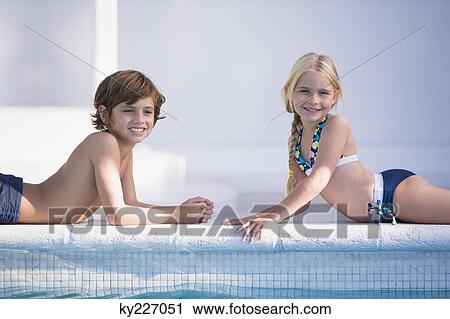 Boy with a girl lying at the poolside and smiling View Large Photo Image Stock Image - Boy with a girl lying at the poolside and smiling. Fotosearch
