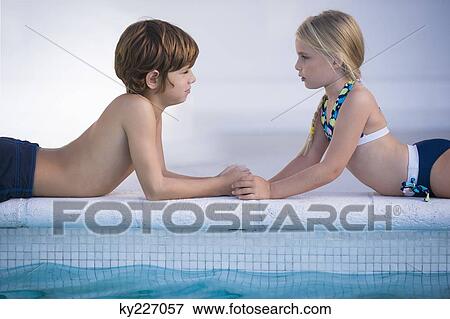Boy with a girl lying at the poolside View Large Photo Image Stock Photo - Boy with a girl lying at the poolside. Fotosearch