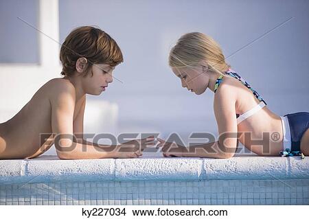 Picture - Boy with a girl playing at the poolside. Fotosearch