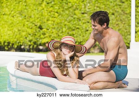 Couple at the poolside View Large Photo Image Stock Image - Couple at the poolside. Fotosearch